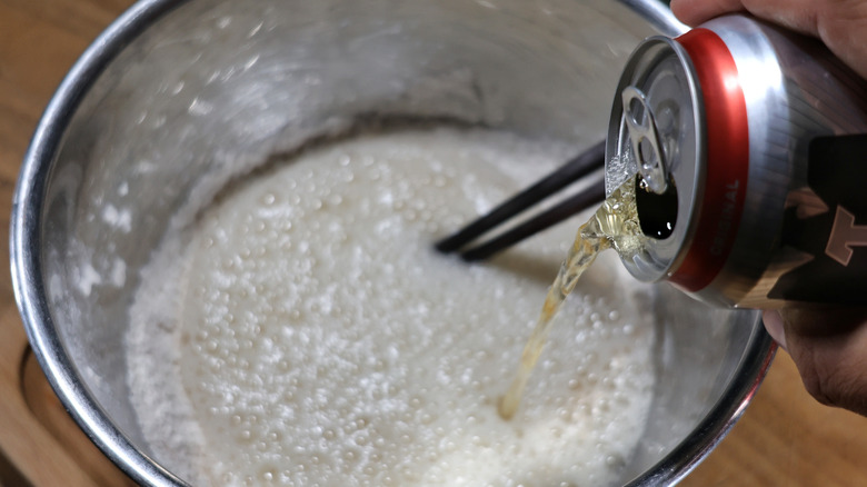 beer pouring into metal mixing bowl full of flour