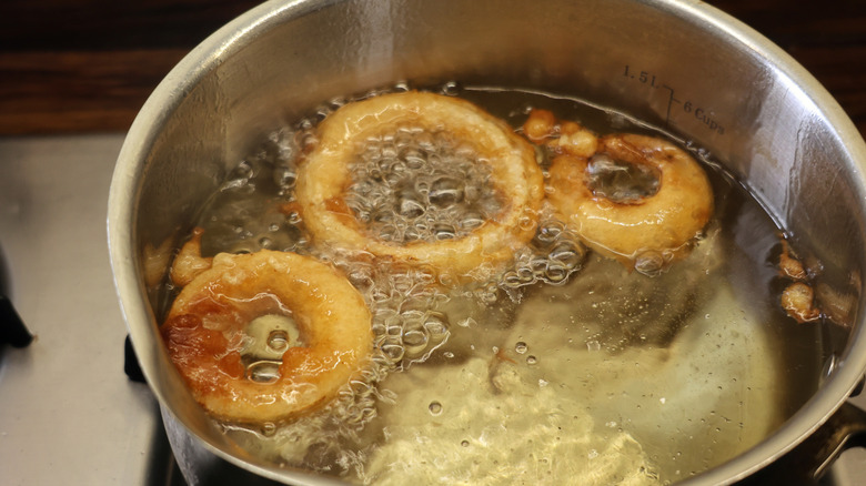 onion rings frying in metal pot