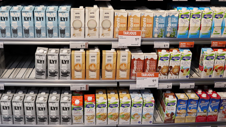 Non-dairy milk cartons on shelves in supermarket