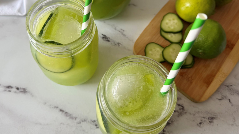 Glasses of sparkling cucumber limeade with straws