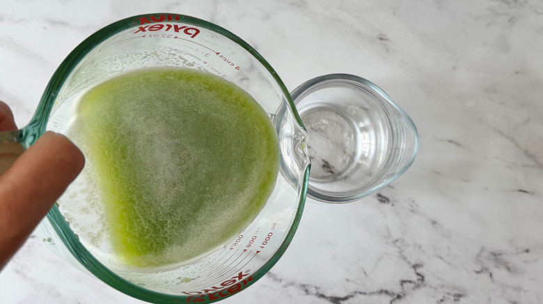 Cucumber juice pouring into pitcher
