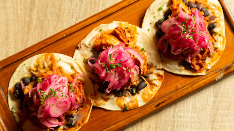 Cochinita pibil tacos on a serving board