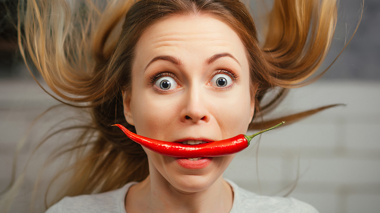 woman with chili pepper in teeth
