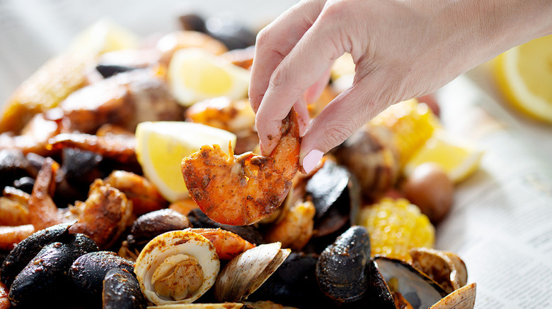 spicy seafood boil on newspaper with lemon wedges