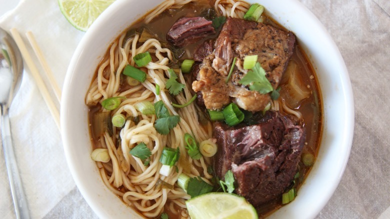 Spicy beef noodle soup with parsley, cilantro, and green onions