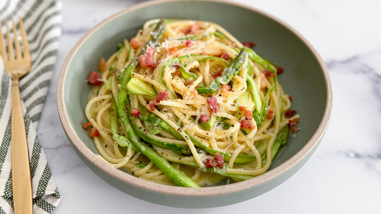 spaghetti carbonara with asparagus in bowl