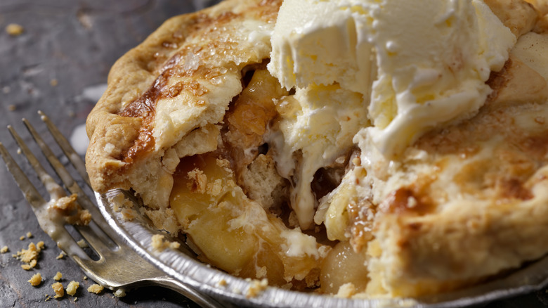 Half-eaten apple pie with ice cream