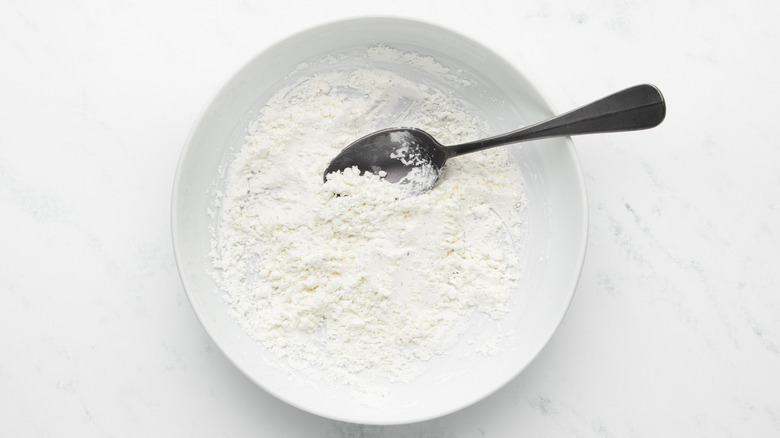Seasoned cornstarch in white dish with spoon