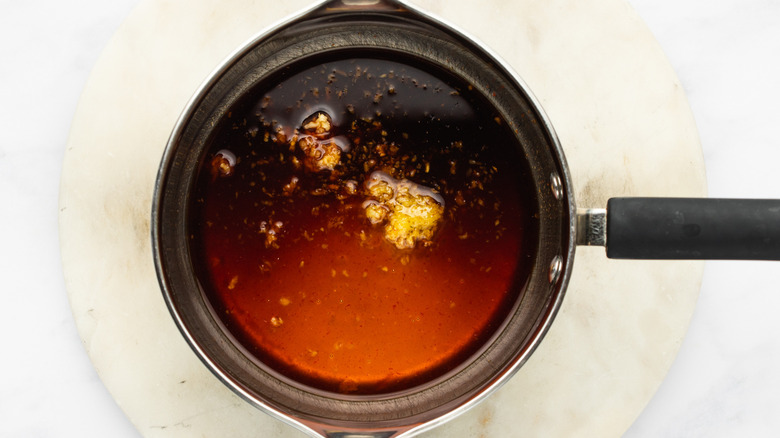Honey sriracha sauce ingredients in saucepan