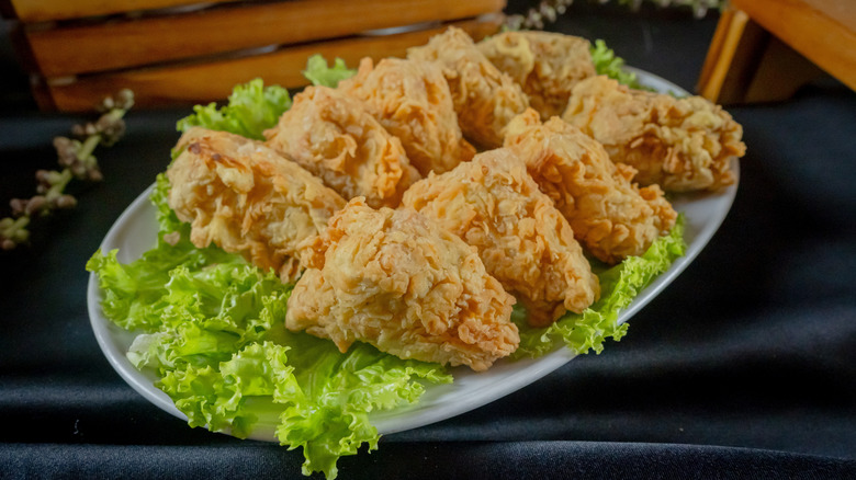 Golden brown, crispy, breaded, and fried tofu bites on a bed of lettuce.