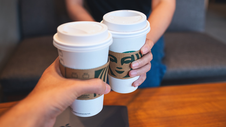 People clinking Starbucks cups