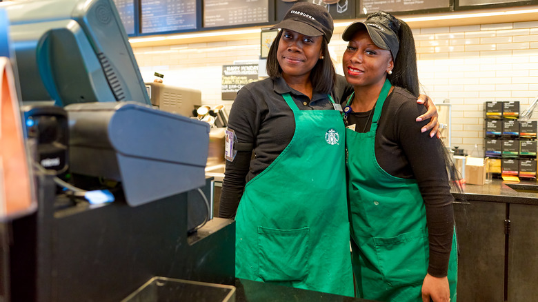 Two Starbucks baristas embracing