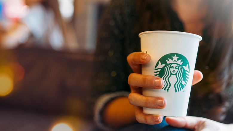 woman with cup of Starbucks coffee