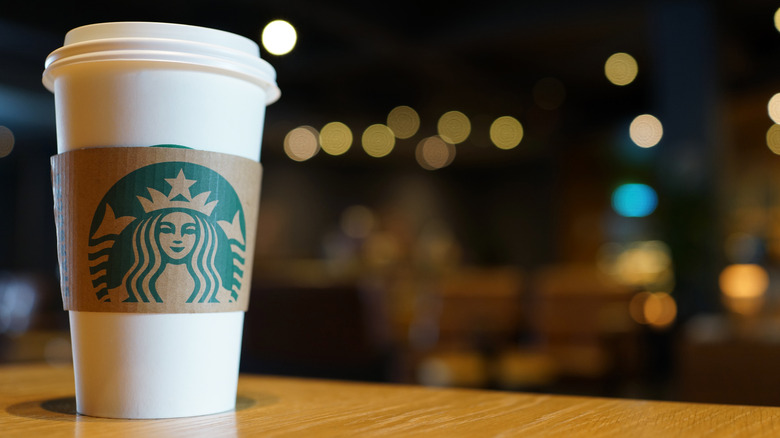 Starbucks Cup with lights in the background