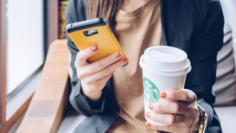 A Starbucks customer checking their phone