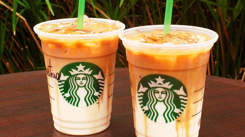 Due bevande Starbucks ghiacciate con sfondo di foglie