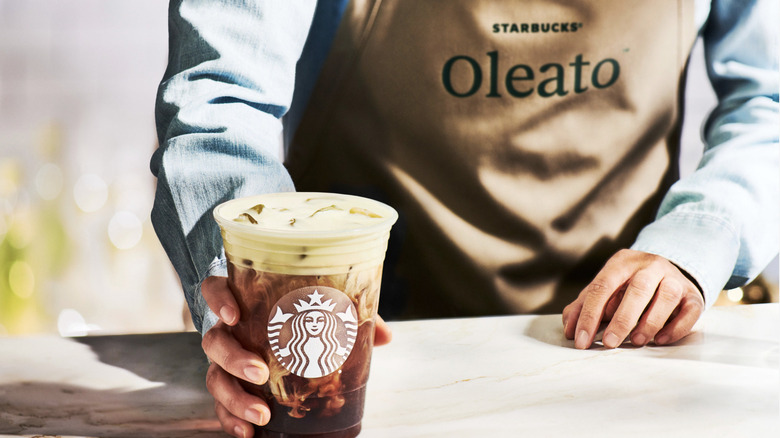 barista holding starbucks oleato drink