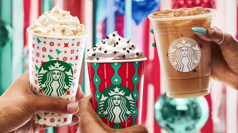 Holiday Starbucks cups in hands