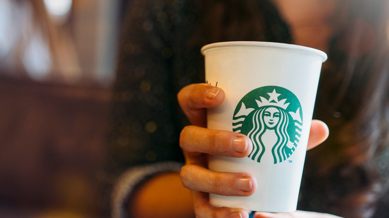 Customer holding a Starbucks cup