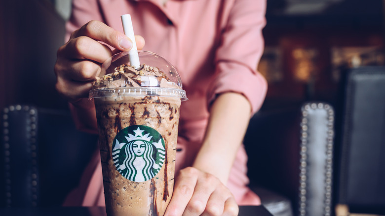 Starbucks barista sliding drink across counter