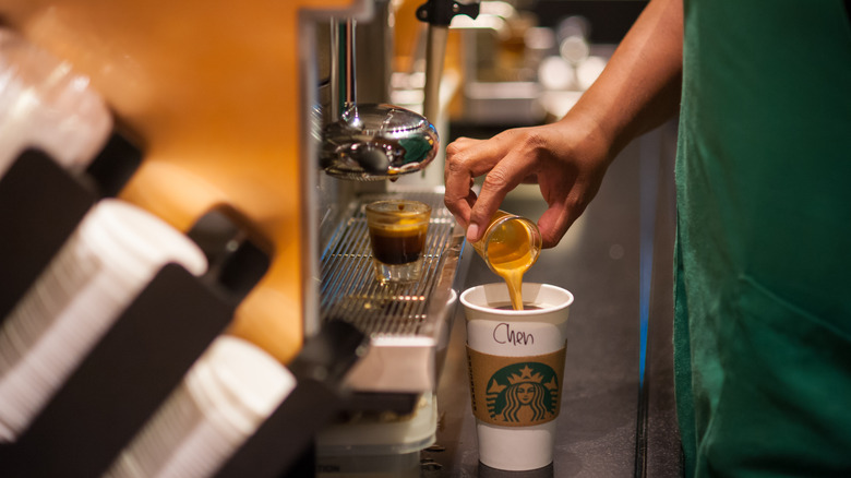 Starbucks worker pouring espresso