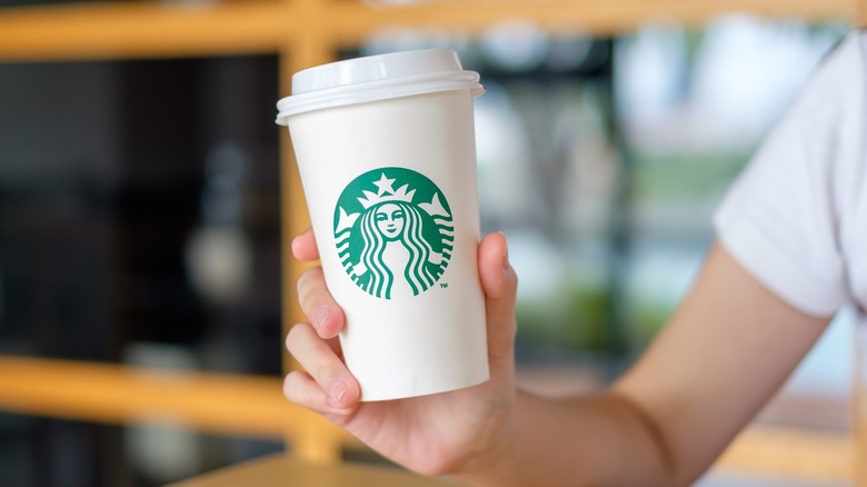 person holding starbucks cup