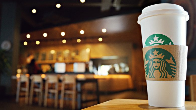 Starbucks cup with store in background