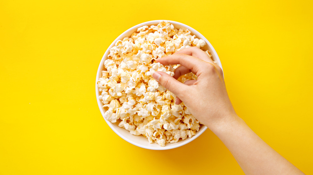 Hand taking popcorn