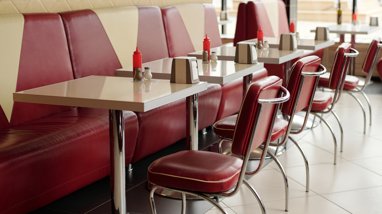 Red retro diner seats with ketchup bottles on tables