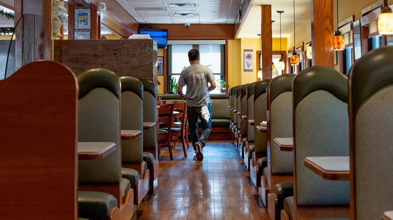 Interior of the Tropicana diner in Elizabeth, New Jersey with rows of gray booths and brown wood floor
