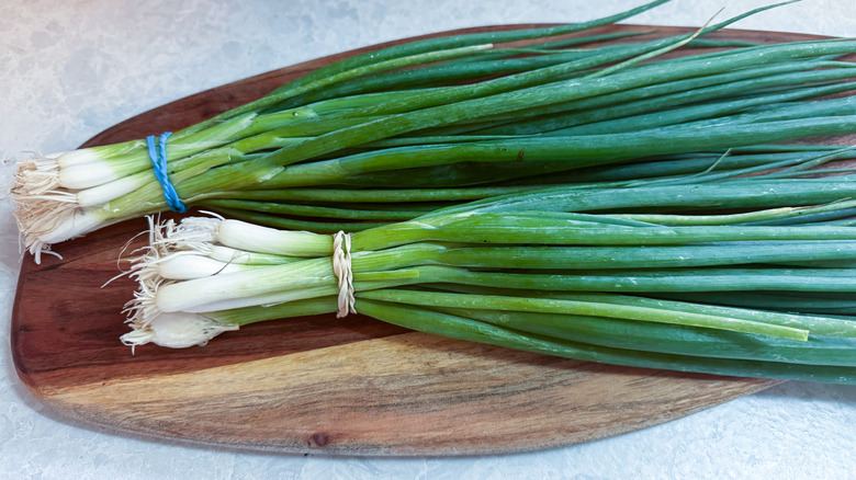 Bunches of scallions on a wood cutting board