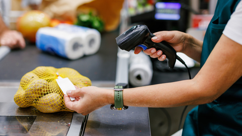 Supermarket cashier scanning items at checkout