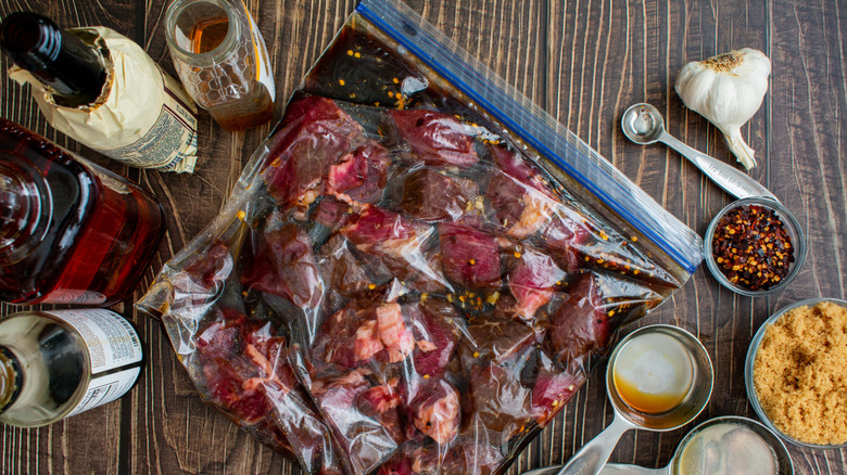 Beef marinating in bag next to seasonings and spices