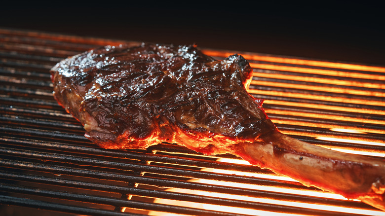 Bone-in ribeye on flaming grill