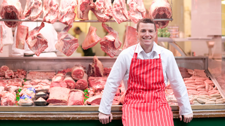 Butcher in front of meat