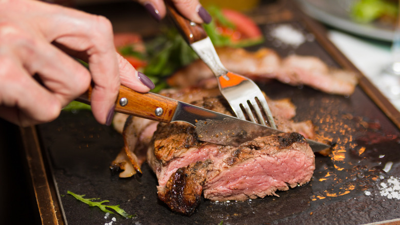 Woman cutting a steak