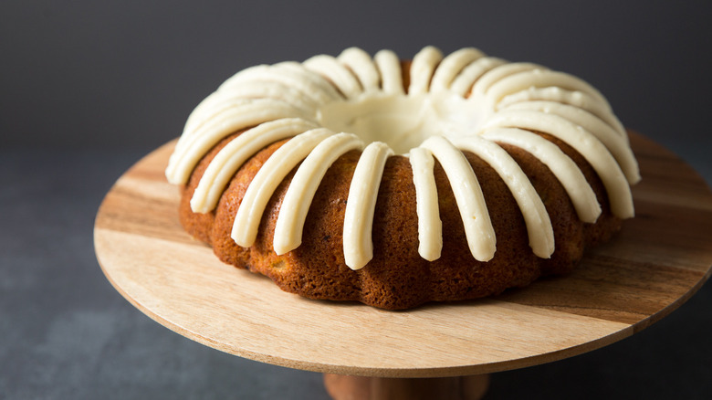 iced carrot bundt cake on stand