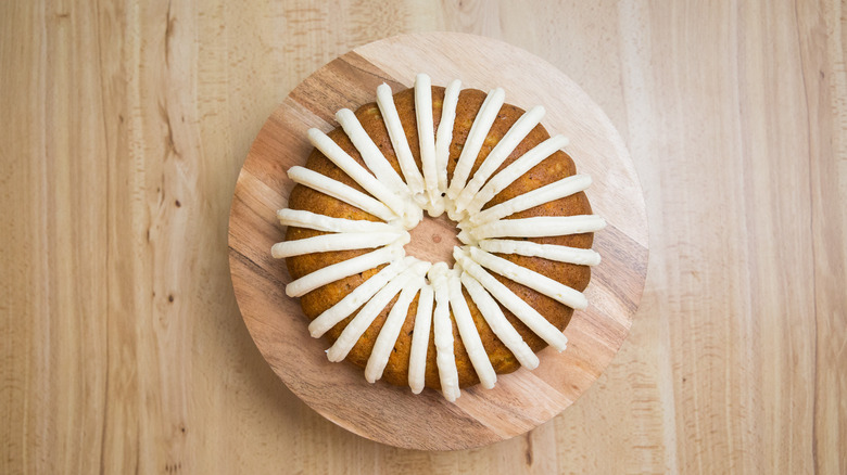 iced carrot bundt cake on stand