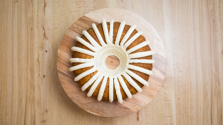 iced carrot bundt cake on stand