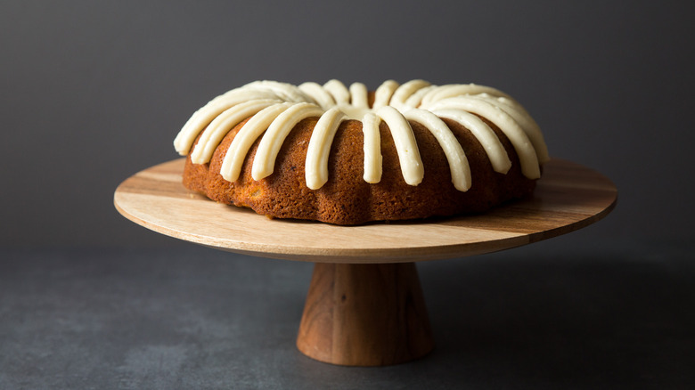 iced carrot bundt cake on stand