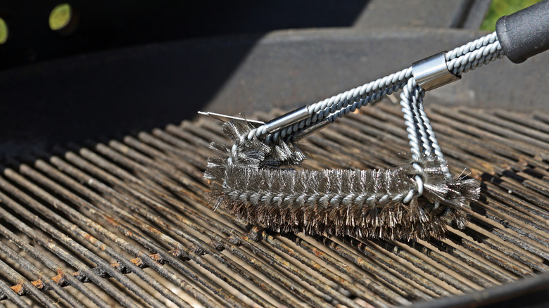 Cleaning a dirty grill with a wire brush
