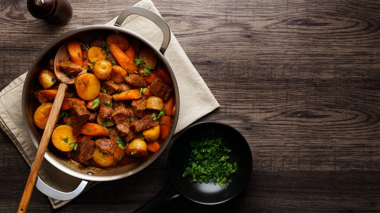 Pot of stew with a wooden spoon