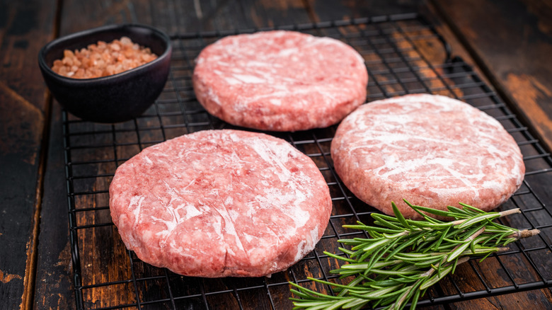 grate with frozen beef patties