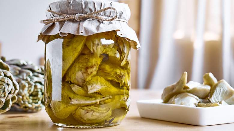 Glass jar of marinated artichokes.