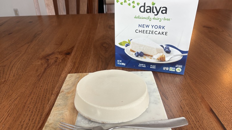 whole small cheesecake on a plate with cheesecake box