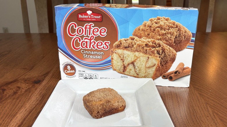 Individual coffee cake square on plate in front of box