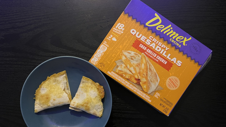 Sliced chicken quesadilla in blue bowl with packaging