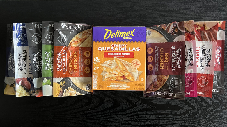Various store-bought frozen quesadillas arranged on black table