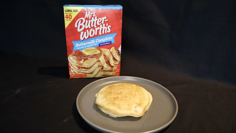 pancake on plate in front of Mrs. Butterworth's box