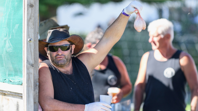man holding up testicles at food festival